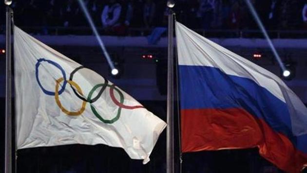 File photo of the Russian national flag, right, flies next to the Olympic flag.(AP)