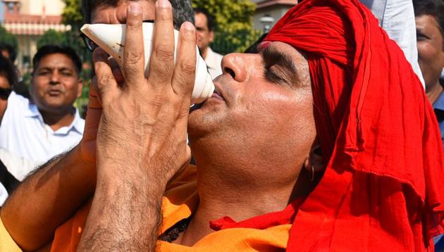 A Hindu devotee blows a conch shell in celebration after the verdict in the Ram Janmabhoomi case.(Sanchit Khanna/HT PHOTO.)