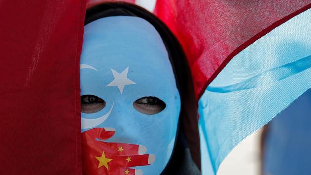 An ethnic Uighur demonstrator wears a mask as she attends a protest against China in front of the Chinese Consulate in Istanbul, Turkey.(REUTERS) An ethnic Uighur demonstrator wears a mask as she attends a protest against China in front of the Chinese Consulate in Istanbul, Turkey.(REUTERS)