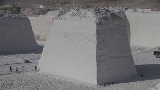 Labourers walk at the White Mountain limestone extraction quarry site. Abu Ibram would like to earn more, but sees no other career options for himself. “I have been working here for 20 years. I left my father and brother and I have no other field of expertise,” he said. “But I don’t like to complain much,” he concluded. (Khaled Desouki / AFP)