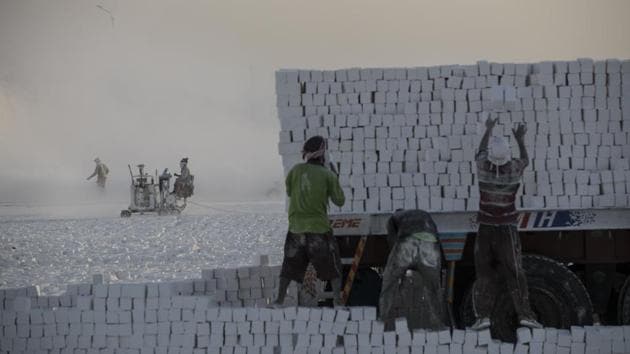 Labourers load limestone blocks on the back of a truck. This same stone was the construction material of choice for cladding pyramids and tombs in ancient Egypt. The site AFP visited has 16 shift workers and a foreman. (Khaled Desouki / AFP)