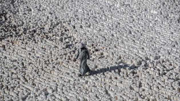 A labourer walks over cut stone blocks at the White Mountain quarry site. “Nearly 400 quarries have been closed east of the Nile but there are about 350 to 400 still operating,” said Abu Ibram, who has been toiling in the same dangerous industry since he was 14. The daily wage for labourers is little more than 100 pounds ($6), barely enough to support a family. (Khaled Desouki / AFP)