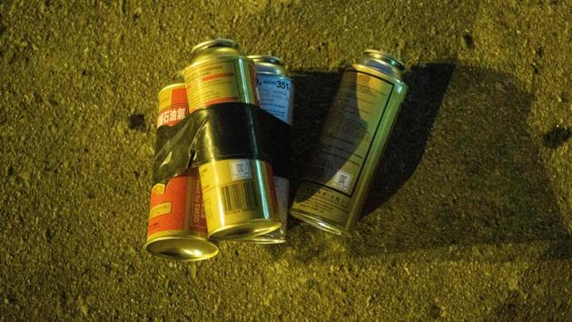 Butane fuel canisters -- used by protesters for throwing into burning barricades -- are seen on a road outside the main entrance of the campus. (Anthony Wallace / AFP) Butane fuel canisters -- used by protesters for throwing into burning barricades -- are seen on a road outside the main entrance of the campus. (Anthony Wallace / AFP)