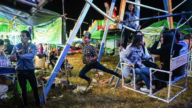 Crew members operate a human-powered ferris wheel in Taunggyi, Shan state. Aung Sein Phyo (not pictured), is among the crew and can be seen careering towards the ground, hanging from one arm on the basket of one of Myanmar’s human-powered Ferris wheels, reliant on gravity-defying agility and split-second coordination honed since the age of nine. (Ye Aung Thu / AFP) Crew members operate a human-powered ferris wheel in Taunggyi, Shan state. Aung Sein Phyo (not pictured), is among the crew and can be seen careering towards the ground, hanging from one arm on the basket of one of Myanmar’s human-powered Ferris wheels, reliant on gravity-defying agility and split-second coordination honed since the age of nine. (Ye Aung Thu / AFP)