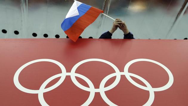 A Russian skating fan holds the country's national flag over the Olympic rings.(AP) A Russian skating fan holds the country's national flag over the Olympic rings.(AP)