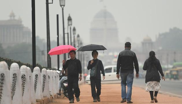 New Delhi, India - Nov. 27, 2019: Pedestrians carry umbrellas during sudden rain that brought down the temperature of the city, at Rajpath, in New Delhi, India, on Wednesday, November 27, 2019. (Photo by Raj K Raj / Hindustan Times)(Raj K Raj/HT PHOTO)