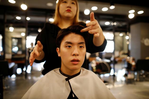 Hwang Hyeon-dong has his hair cut before taking photos for his resume in Guri. Cho and his college professor wife were accused of using their positions to help their daughter gain admission to medical school in 2015. Cho acknowledged he was a gold spoon and a “Gangnam liberal” motivated by social justice, but the approach backfired and he stepped down in October after only a month in the post. (Kim Hong-Ji / REUTERS)