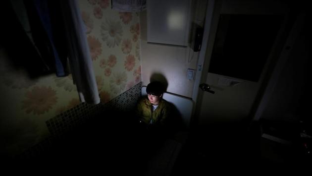 Kim Jae-hoon looks at his mobile phone before going to sleep. The fact that gold and dirt spoons are portrayed in popular culture in such a diverse range is reflective of the bitter hopelessness among the have-nots, said Kim Jong-min, the leader of civic group Youth Taeil, which supports young jobseekers and temporary workers. (Kim Hong-Ji / REUTERS)