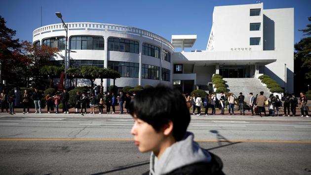 Kim Jae-hoon walks past people waiting at a bus stop, as he makes his way to Kyung Hee University in Suwon. “If I try hard enough and get a good job, will I ever be able to afford a house?” said the 25-year-old, who lives in his small, cluttered room where clothes were piled on the bed. “Will I ever be able to narrow the gap that’s already so big?” (Kim Hong-Ji / REUTERS)