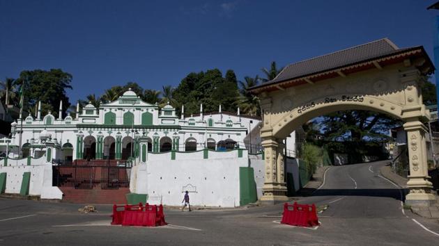 A man walks past the Meera Maccam Jummah Masjid standing beside a Buddhist arch in Kandy. There is doubt about Rajapaksa’s promise among the Muslims of Kandy, a city home to Buddhism’s venerated Temple of the Sacred Tooth. Muslims here speak in hushed tones about what Rajapaksa’s rise to power could mean in a place that even before the Easter attacks saw deadly mob violence aimed at them. (Dar Yasin / AP)