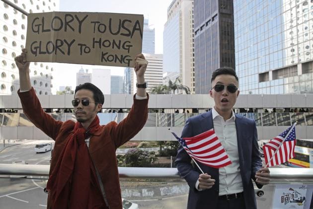 Protesters hold American flags and placard during a demonstration in Central, the financial district of Hong Kong, Thursday, Nov. 28, 2019.(AP)