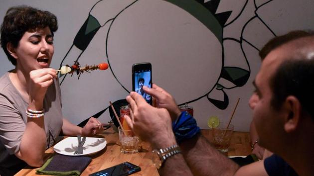 A tourist (L) holds up skewered cricket and spiders for a picture at the Bugs Cafe restaurant in Siem Reap province, Cambodia. Ant spring rolls, silkworm taro croquettes and a “bug mac” -- Cambodia’s first insect tapas restaurant is mixing cocktail culture with creepy crawler fare. (Tang Chhin Sothy / AFP) A tourist (L) holds up skewered cricket and spiders for a picture at the Bugs Cafe restaurant in Siem Reap province, Cambodia. Ant spring rolls, silkworm taro croquettes and a “bug mac” -- Cambodia’s first insect tapas restaurant is mixing cocktail culture with creepy crawler fare. (Tang Chhin Sothy / AFP)