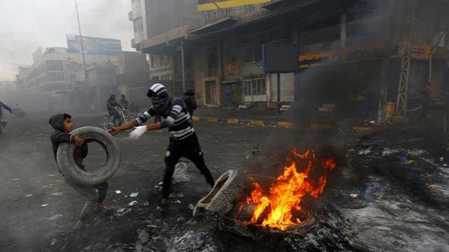 Iraqi demonstrators burn tires to block a street during ongoing anti-government protests in Najaf, Iraq November 28, 2019.(REUTERS)