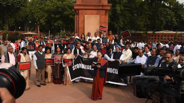 Congress President Sonia Gandhi reads the constitution near the statue of Baba Saheb Bhimrao Ambedkar during a protest by members of the Opposition in Parliament after they boycotted the joint address that was called to commemorate the Constitution Day, owing to political developments and government formation in Maharashtra, on November 26. (Mohd Zakir / HT Photo)