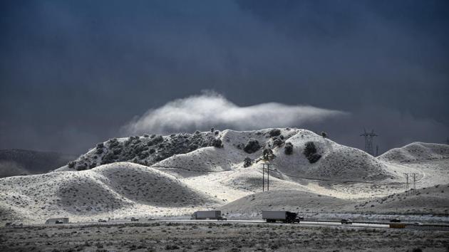 A dramatic sky opens up between snow squalls along the Interstate 5 freeway near Gorman, California, US. Plows were running and CHP escorted traffic in an attempt to keep the freeway open as long as possible. (David Crane / The Orange County / AP)