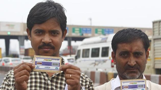 Men hold their FASTags, at the toll office, Jaipur-Delhi side, at Kherki-Daula toll plaza, in Gurugram.(Yogendra Kumar/HT PHOTO)