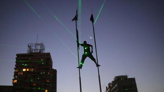A demonstrator climbs up flag poles as demonstrators shine lasers during a protest against Chile’s government, in Santiago, Chile. (Pablo Sanhueza / REUTERS)