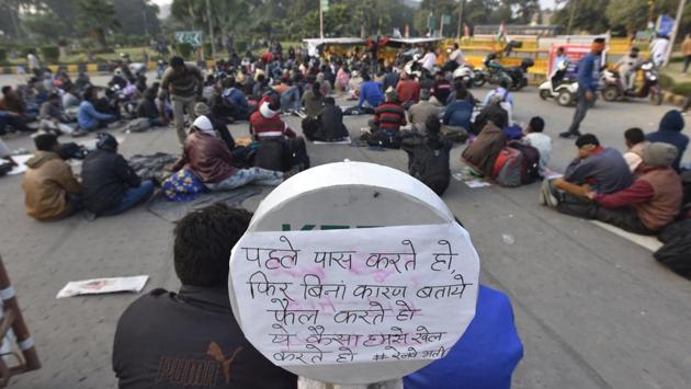 A placard is seen as differently-abled people hold a sit-in protest for the fifth consecutive day against the irregularities in the exam results for railways, at Mandi House circle in New Delhi. (Sonu Mehta/HT Photo)