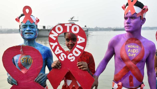Thalassaemia and AIDS Prevention Society activists paint their bodies to raise awareness about AIDS and the stigma faced by HIV positive individuals on the eve of World AIDS Day, at Baje Kadamtala Ghat (Babughat), beside river Hooghly, in Kolkata, West Bengal. (Samir Jana / HT Photo)