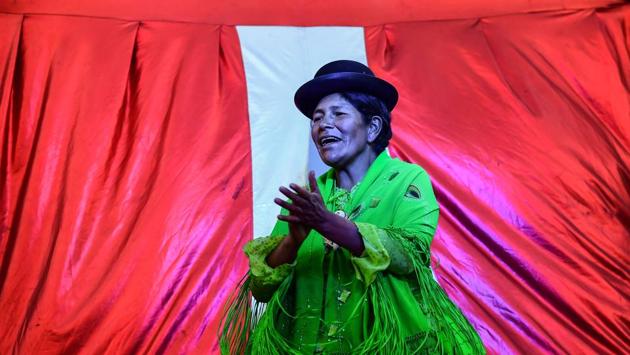Flores, wearing a shawl the same shade of garish green as her flouncy skirt, climbed into the ring and tossed her bowler hat on the floor. To warm up for her mixed pairs fight against Yujra, the plump wrestler performed a couple of running somersaults on the canvas, revealing the lacy layers of her pollera and her underwear to the scores of spectators. (Ronaldo Schemidt / AFP)