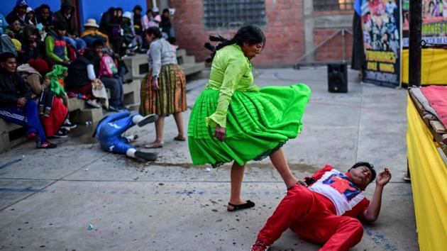 Flores (2-R),and Ana Luisa Yujra (2-L), fight against male wrestlers. The sight of male and female wrestlers stomping, beating, choking and spraying water on each other does not bother the crowd as they egg on the performers to go even further. “It is a demonstration for us of a woman defending herself against men,” Norah Martinez Salazar, 34, told AFP. “It seems rough, but it’s something interesting.” (Ronaldo Schemidt / AFP)