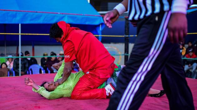 After an intense battle peppered with references to the political crisis gripping the country, Yujra and her male partner decked out in shiny red trousers and matching top, were declared the winners. A visibly exhausted and dishevelled Flores blew kisses to her fans as she left the ring defeated. “I feel bad,” she said. “I’m really tired and out of breath.” (Ronaldo Schemidt / AFP)