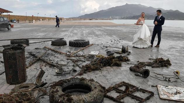 A newly-wed couple looks at rubbish collected from the sea by volunteers. George Triantafyllou, the HCMR’s head of research, says the institute is coordinating a European project, Claim, across 13 EU countries in addition to Tunisia and Lebanon to eliminate microplastics. The project includes developing photocatalytic technology to accelerate the degradation of microplastics in seas and rivers, he noted. (Louisa Gouliamaki / AFP)