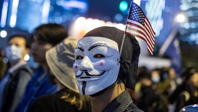 A demonstrator wears an anonymous mask, also known as a Guy Fawkes mask, and an American flag during the Thanksgiving Day Assembly for Hong Kong Human Rights and Democracy Act" at Edinburgh Place in the Central district of Hong Kong, China (Bloomberg/ Representative Image) A demonstrator wears an anonymous mask, also known as a Guy Fawkes mask, and an American flag during the Thanksgiving Day Assembly for Hong Kong Human Rights and Democracy Act" at Edinburgh Place in the Central district of Hong Kong, China (Bloomberg/ Representative Image)