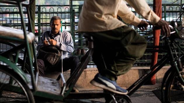 Vinod Kumar Sharma sits outside a temple after saying his prayers on his way to the Blind Relief Association. Many roads lack pavements, forcing the 44-year-old father-of-three to walk on the roadside, probing his white cane in front as cars and trucks tear past just inches away. (Xavier Galiana / AFP)