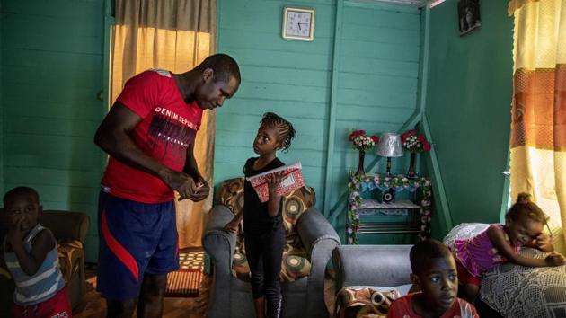 Fisherman Damian Brown helps his daughter Mishaunda, with her homework as other children watch television in their home. Brown, 33, has been caught twice. He’s been fined, had his equipment taken away and almost went to jail. He fears a third time could bring a fine he can’t afford to pay, plus jail time. He sees the benefit of the sanctuaries, but argues the boundaries extend too far. (David Goldman / AP)