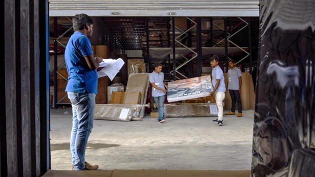 Workers load a product onto a vehicle as part of the dispatch process to customers at a warehouse. From ride-hailing apps to communal office spaces, the sharing economy is a global phenomenon that is expected to generate annual revenues of $335 billion by 2025, according to PricewaterhouseCoopers. In India, the boom has fuelled the rise of new furniture and appliance-renting businesses such as Furlenco, RentoMojo and GrabOnRent -- and even jewellery rental apps -- in recent years. (Manjunath Kiran / AFP)