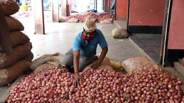 A workers sorts onions at a market in Pune. The price range from Rs100 to Rs120 per kg at APMC. (HT PHOTO) A workers sorts onions at a market in Pune. The price range from Rs100 to Rs120 per kg at APMC. (HT PHOTO)