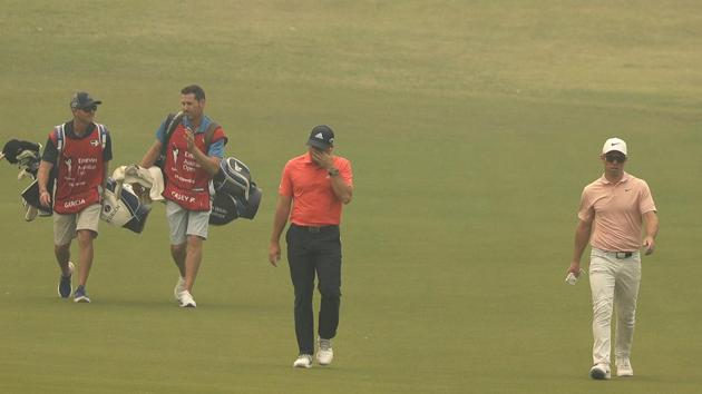Spain's Sergio Garcia, front left, and Britain's Paul Casey, front right, walk down the 12th fairway as smoke haze engulfs the course. (AP) Spain's Sergio Garcia, front left, and Britain's Paul Casey, front right, walk down the 12th fairway as smoke haze engulfs the course. (AP)
