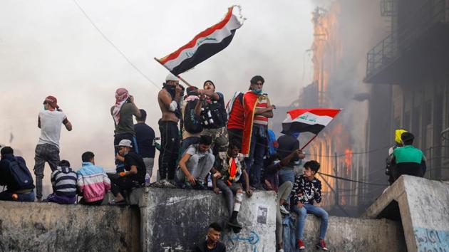 A demonstrator carries the Iraqi flag during ongoing anti-government protests, in Baghdad, Iraq. (Kahlid al-Mousily / REUTERS)