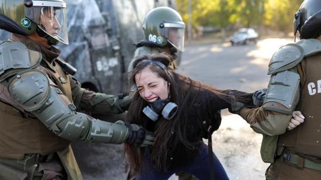 A demonstrator reacts as she is detained by riot policemen during a protest against Chile’s government in Santiago, Chile. (Pablo Sanhueza / REUTERS)