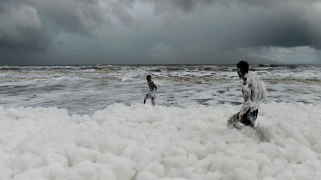 Residents play over foamy discharge, caused by pollutants, as it mixes with the surf at Marina beach in Chennai, Tamil Nadu. (Arun Sankar / AFP) Residents play over foamy discharge, caused by pollutants, as it mixes with the surf at Marina beach in Chennai, Tamil Nadu. (Arun Sankar / AFP)