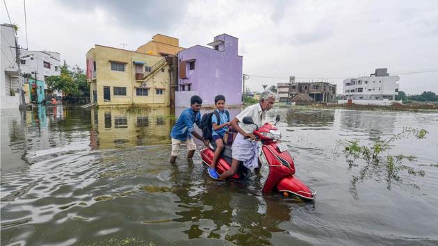 A man pushes his scooter through the flood-water in a suburban locality, after heavy rains in Chennai, Tamil Nadu. (PTI) A man pushes his scooter through the flood-water in a suburban locality, after heavy rains in Chennai, Tamil Nadu. (PTI)