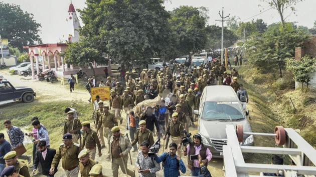 Police personnel march as family members and relatives carry the mortal remains of Unnao rape victim for burial at Unnao, Sunday, Dec. 8, 2019.(PTI)