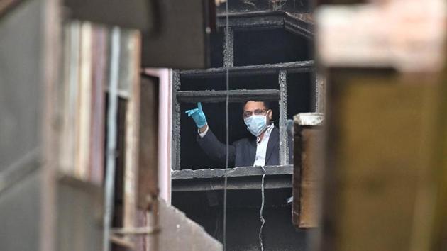 A member of the Delhi police forensic team during his investigation at the site today. Despite a history of major fire incidents, which claimed scores of lives, Sunday’s incident was a glaring eye-opener to the apathy of government agencies towards the implementation of fire safety and building laws. (Raj K Raj / HT Photo)