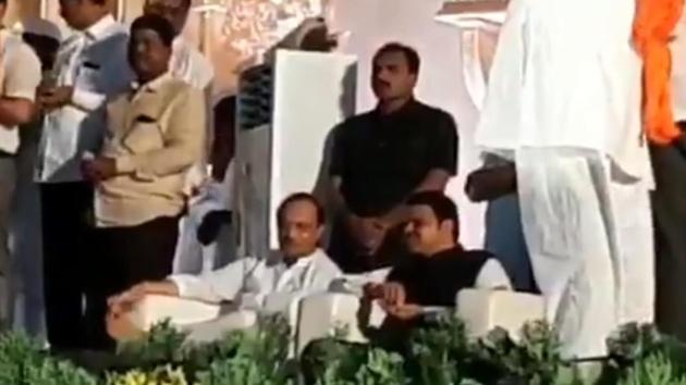 NCP’s Ajit Pawar sitting next to Devendra Fadnavis at a wedding in Solapur. (Video grab) NCP’s Ajit Pawar sitting next to Devendra Fadnavis at a wedding in Solapur. (Video grab)