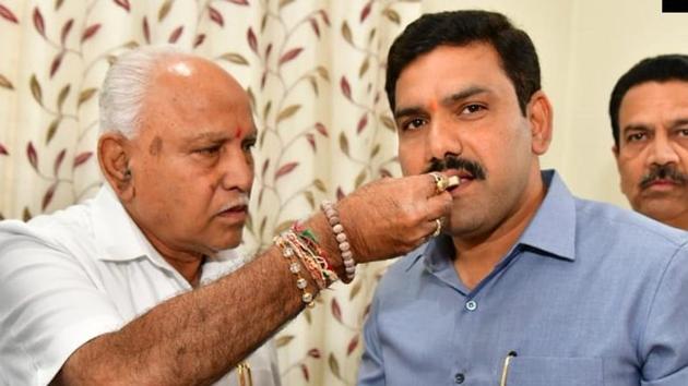Karnataka Chief Minister BS Yediyurappa celebrates the bypoll results with his son BY Vijayendra.(ANI Photo)