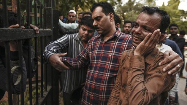 A family member of a worker mourns his death outside a mortuary at Lok Nayak Hospital. Doctors said most of the deaths were due to people inhaling poisonous gases inside the already cramped premises. “Some of the patients have superficial burn injuries but the problem is that most of them have inhaled a lot of smoke,” said Dr Kishore Singh, medical director of the hospital. (Burhaan Kinu / HT Photo)