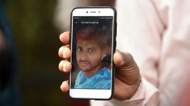 A relative shows a file photo of Mohammad Zakir who lost his life in the fire. Babar Ali, 32, rescued his sister-in-law Maisuma Bibi, who was woken from her bed on the ground of a first-floor handbag factory. Ali said the lives of the migrant workers, who were paid between ₹7,000 and 10,000 a month, was “a bigger tragedy than their death.” (Amal KS / HT Photo)