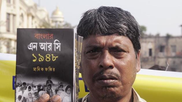 An activist holds a book during the mass rally protest against the National Register of Citizens (NRC), and CAB, in Kolkata. (ANI Photo) An activist holds a book during the mass rally protest against the National Register of Citizens (NRC), and CAB, in Kolkata. (ANI Photo)