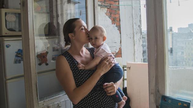 Anna Sergeyeva poses for a photo with her daughter in her flat in Kyiv. In May 2014, Sergeyeva was snatched from her apartment in Donetsk by Russia-backed separatists and was being beaten and stabbed for six days before they let her go. Haunted by memories of torture and pain, Sergeyeva had to flee from the only life she knew and start anew — with no place to live, no job and no support from the government. (Zoya Shu / AP)