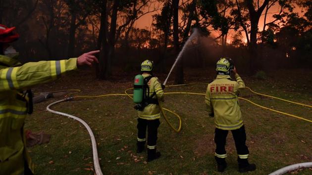 Fire fighting crews from the Rural Fire Service (RFS), NSW Fire and Rescue and National Parks and Wildlife Service (NPWS) officers fight a bushfire encroaching on properties near Lake Tabourie, Australia.More 100 fires remain ablaze in the region, and authorities warned conditions would worsen on Tuesday, when temperatures were predicted to top 40 degrees Celsius. (AAP Image/Dean Lewins/via REUTERS ) Fire fighting crews from the Rural Fire Service (RFS), NSW Fire and Rescue and National Parks and Wildlife Service (NPWS) officers fight a bushfire encroaching on properties near Lake Tabourie, Australia.More 100 fires remain ablaze in the region, and authorities warned conditions would worsen on Tuesday, when temperatures were predicted to top 40 degrees Celsius. (AAP Image/Dean Lewins/via REUTERS )