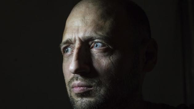 Dmytro Kluger, looks at a window posing for a photo in his home. Kluger was detained in May 2014 by separatist insurgents in Donetsk and later tried to commit suicide in captivity. For many, helping other former captives is often a way to advance their own recovery. They form support groups, non-governmental organizations and raise money for other survivors. (Zoya Shu / AP)
