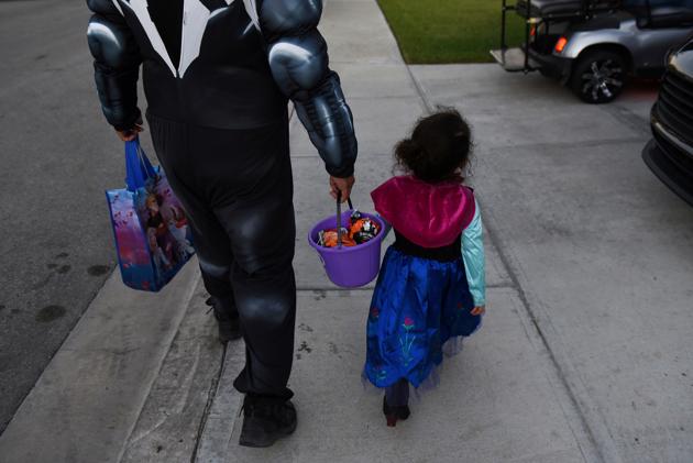 Zak Tiemann helps his daughter to carry her candy bucket. “I just feel like they’re missing something,” Tiemann said. “Even though I’m doing the best I can... they still need a woman that’s going to show them how to go about stuff in life.” (Callaghan O'Hare / REUTERS) Zak Tiemann helps his daughter to carry her candy bucket. “I just feel like they’re missing something,” Tiemann said. “Even though I’m doing the best I can... they still need a woman that’s going to show them how to go about stuff in life.” (Callaghan O'Hare / REUTERS)
