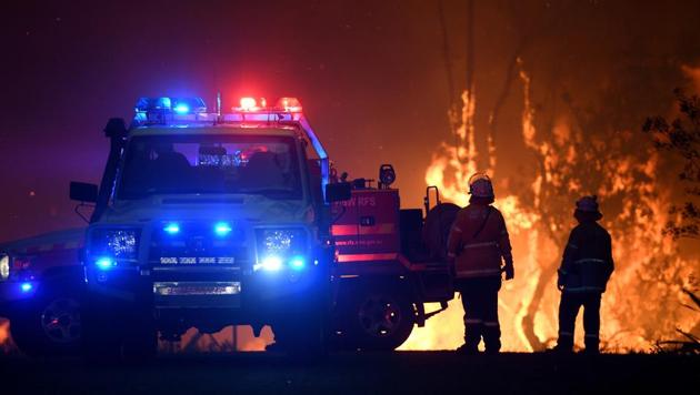 NSW Rural Fire Service crews protect properties on Waratah Road and Kelyknack Road as the Three Mile fire approaches Mangrove Mountain, Australia. Thousands of firefighters were fortifying containment lines on Monday as temperatures were forecast to soar, increasing the danger of a fresh wave of bushfires across Australia’s east coast. (AAP Image/Dan Himbrechts/via REUTERS) NSW Rural Fire Service crews protect properties on Waratah Road and Kelyknack Road as the Three Mile fire approaches Mangrove Mountain, Australia. Thousands of firefighters were fortifying containment lines on Monday as temperatures were forecast to soar, increasing the danger of a fresh wave of bushfires across Australia’s east coast. (AAP Image/Dan Himbrechts/via REUTERS)