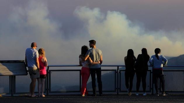 People watch as smoke from the Green Wattle Creek fire is seen from Echo Point lookout in Katoomba, as bushfires continue to blaze in New South Wales, Australia. Wildfires have killed at least four people, destroyed more than 680 homes and burned more than 2.5 million acres (1 million hectares) of bushland across eastern Australia since the start of November. (AAP/Steven Saphore via REUTERS) People watch as smoke from the Green Wattle Creek fire is seen from Echo Point lookout in Katoomba, as bushfires continue to blaze in New South Wales, Australia. Wildfires have killed at least four people, destroyed more than 680 homes and burned more than 2.5 million acres (1 million hectares) of bushland across eastern Australia since the start of November. (AAP/Steven Saphore via REUTERS)